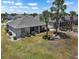 Aerial view of the backyard featuring a screened lanai, landscaped gardens, and a well-manicured lawn at 1112 Jasmine Creek Ct, Sun City Center, FL 33573