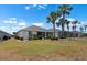 Expansive backyard features lush landscaping, mature palm trees, and a screened-in lanai at 1112 Jasmine Creek Ct, Sun City Center, FL 33573