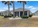 Well-maintained backyard features manicured landscaping, palm trees, and a screened-in lanai at 1112 Jasmine Creek Ct, Sun City Center, FL 33573