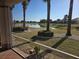 Backyard view from screened lanai showcasing a tranquil lake and manicured landscaping at 1112 Jasmine Creek Ct, Sun City Center, FL 33573