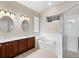 Bright bathroom features double vanity, soaking tub, and glass-enclosed shower at 1112 Jasmine Creek Ct, Sun City Center, FL 33573