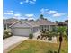 Single-story home with a two-car garage, neatly landscaped front yard, and a well-maintained driveway at 1112 Jasmine Creek Ct, Sun City Center, FL 33573