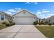 Two car garage with concrete driveway and mature landscaping at 1112 Jasmine Creek Ct, Sun City Center, FL 33573