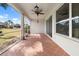 Screened lanai with tile flooring, ceiling fan, and views of the lush green backyard at 1112 Jasmine Creek Ct, Sun City Center, FL 33573