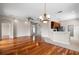 Open concept living room with hardwood floors, ceiling fan, and kitchen area with stainless steel appliances at 1112 Jasmine Creek Ct, Sun City Center, FL 33573