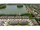 Aerial view features townhomes near lake; landscaping & garages highlighted at 11442 Crowned Sparrow Ln, Tampa, FL 33626