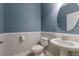Charming half bathroom with a pedestal sink, round mirror, and modern fixtures at 11442 Crowned Sparrow Ln, Tampa, FL 33626