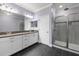 Modern bathroom with a dual sink vanity and walk-in shower featuring glass doors at 11442 Crowned Sparrow Ln, Tampa, FL 33626