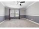Comfortable bedroom boasts neutral carpet, a ceiling fan, and large windows at 11442 Crowned Sparrow Ln, Tampa, FL 33626