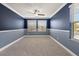 Inviting bedroom with two windows providing natural light and neutral colored carpet at 11442 Crowned Sparrow Ln, Tampa, FL 33626