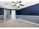 Bedroom showcasing plush carpet, tray ceilings, modern ceiling fan and stylish two-toned walls at 11442 Crowned Sparrow Ln, Tampa, FL 33626