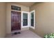 Welcoming front porch with a brick-tiled floor, decorative window, and a solid wood front door at 11442 Crowned Sparrow Ln, Tampa, FL 33626