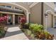 Inviting entrance with colorful plants and archways leading to a dark wood front door at 11442 Crowned Sparrow Ln, Tampa, FL 33626