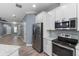 Modern kitchen features stainless steel appliances, white cabinets, and granite countertops at 11442 Crowned Sparrow Ln, Tampa, FL 33626