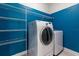Functional laundry room with washer, dryer, and shelving for storage at 11442 Crowned Sparrow Ln, Tampa, FL 33626