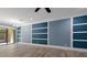 Open-concept living room with wood-look tile flooring, custom wall paneling, and sliding glass doors at 11442 Crowned Sparrow Ln, Tampa, FL 33626