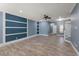 Spacious living room with wood-look tile flooring, custom wall paneling, and a staircase at 11442 Crowned Sparrow Ln, Tampa, FL 33626