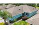 Aerial shot of a blue home featuring a well-maintained roof, lush landscaping, and a serene neighborhood at 11457 Captiva Kay Dr, Riverview, FL 33569