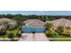 Overhead view of blue home with two-car garage, neatly manicured lawn, and surrounded by a charming neighborhood at 11457 Captiva Kay Dr, Riverview, FL 33569