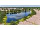 Expansive aerial view of a neighborhood with a large pond, green lawns, and colorful homes at 11457 Captiva Kay Dr, Riverview, FL 33569