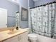 Well-lit bathroom featuring a vanity with a neutral countertop, ample storage, and a stylish shower curtain at 11457 Captiva Kay Dr, Riverview, FL 33569