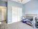 Charming Bedroom showcasing a crib with a cozy blanket, a spacious closet, and soft, inviting colors at 11457 Captiva Kay Dr, Riverview, FL 33569