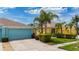 Charming yellow home with a blue garage, lovely landscaping, and well-maintained front yard at 11457 Captiva Kay Dr, Riverview, FL 33569
