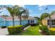 Charming exterior of blue home showcasing a two-car garage and well-maintained tropical landscaping at 11457 Captiva Kay Dr, Riverview, FL 33569