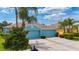 Lovely exterior of a blue home with a two-car garage and tidy landscaping complemented by mature palm trees at 11457 Captiva Kay Dr, Riverview, FL 33569
