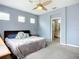 Calm bedroom with decorative pillows, a ceiling fan, and access to an ensuite bathroom with great natural lighting at 11457 Captiva Kay Dr, Riverview, FL 33569