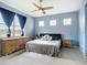 Relaxing bedroom featuring large windows, a ceiling fan, and a dresser with drawers and doors on the right side at 11457 Captiva Kay Dr, Riverview, FL 33569