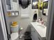 Bright bathroom with white vanity, white toilet, decorative accents, and overhead storage at 1165 Falcon Dr, Dunedin, FL 34698
