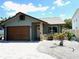Charming single Gathering home with stone accents, decorative gravel, and a well-manicured lawn at 1165 Falcon Dr, Dunedin, FL 34698