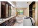 Bathroom featuring a soaking tub, stylish dark wood cabinetry, and bright natural light at 11783 Ashley Ct, Seminole, FL 33772