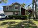 Charming home featuring an attached garage, a well-maintained lawn, and a bright red front door at 11783 Ashley Ct, Seminole, FL 33772