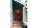 Inviting front entrance with a red door and brick accents, framed by lush greenery at 11783 Ashley Ct, Seminole, FL 33772