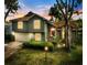 Charming home with a well-maintained lawn, complemented by mature trees and beautiful dusk lighting at 11783 Ashley Ct, Seminole, FL 33772