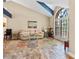 Bright living room featuring a vaulted ceiling, large arched window, and stylish decor at 11783 Ashley Ct, Seminole, FL 33772