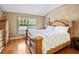 A cozy main bedroom with hardwood floors features a large bed and a window with blinds at 11783 Ashley Ct, Seminole, FL 33772