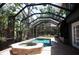 Screened-in pool area features a spa and brick patio, creating a private outdoor oasis at 11783 Ashley Ct, Seminole, FL 33772