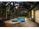 Secluded screened-in pool area with a spa, surrounded by brick pavers and lush greenery at 11783 Ashley Ct, Seminole, FL 33772