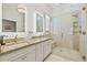 Spa-like bathroom featuring double sinks, granite countertop, a glass-enclosed shower with tiled accents at 11808 Lancashire Dr, Tampa, FL 33626