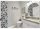 Stylish half bath boasts designer wallpaper, granite vanity, and elegant fixtures at 11808 Lancashire Dr, Tampa, FL 33626
