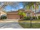 Charming single-story home featuring a well-manicured lawn, mature trees, and an attached two-car garage at 11808 Lancashire Dr, Tampa, FL 33626