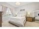 Serene main bedroom features a tufted headboard, chandelier lighting, and neutral tones at 11808 Lancashire Dr, Tampa, FL 33626