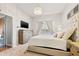 The main bedroom features a tufted headboard, chandelier lighting, and neutral tones at 11808 Lancashire Dr, Tampa, FL 33626