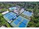 Aerial view showcases community recreational facilities including tennis courts, swimming pool, and wooded surroundings at 11906 Middlebury Dr, Tampa, FL 33626