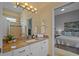 Well-lit bathroom with stone counter, white cabinets and mirror, and view into the bedroom at 11906 Middlebury Dr, Tampa, FL 33626