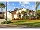 Well-maintained single-story home boasts a lush green lawn, a three-car garage, and an appealing, arched front entrance at 11906 Middlebury Dr, Tampa, FL 33626