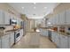 Open kitchen with white cabinetry, stainless steel appliances, granite countertops, and tile flooring at 11906 Middlebury Dr, Tampa, FL 33626